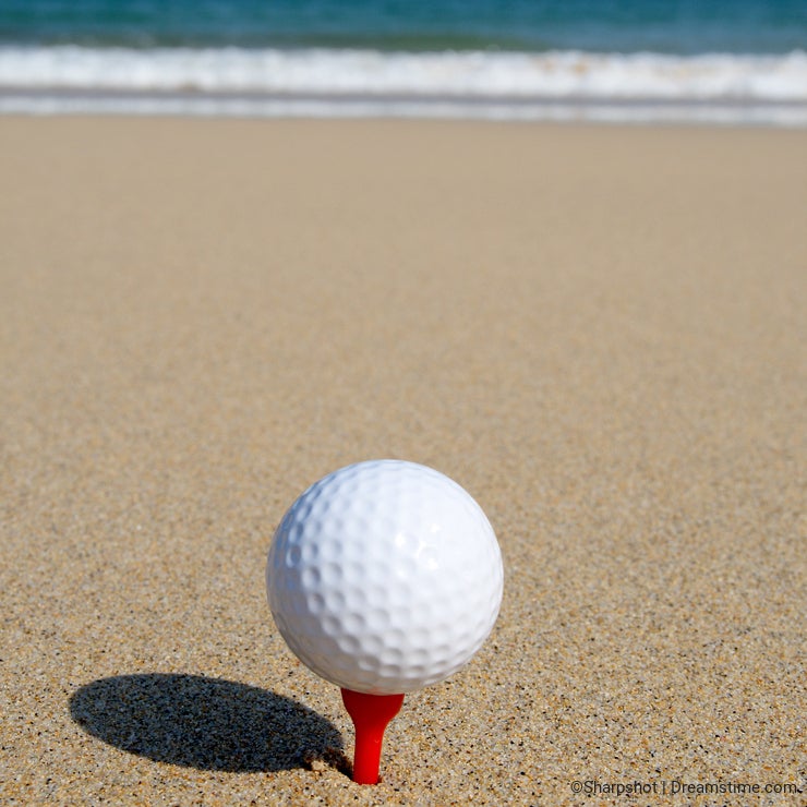 A golf ball on the beach.
