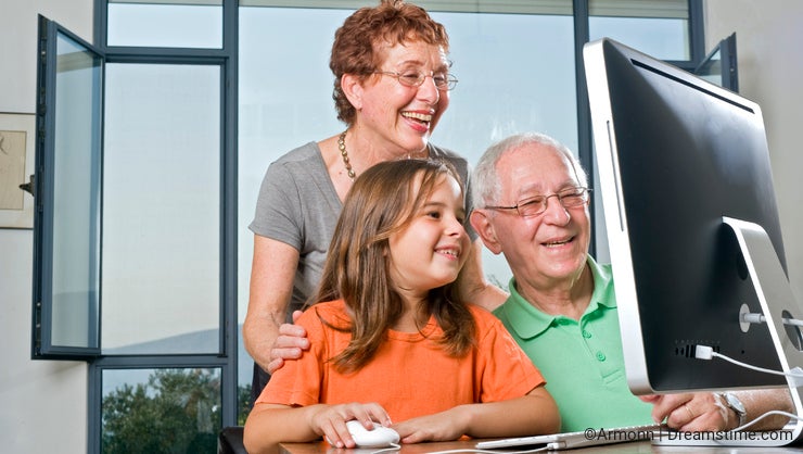 Grandparents and granddaughter with computer