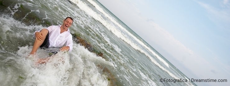 Ocean groom (man in shirt laughing in sea water)