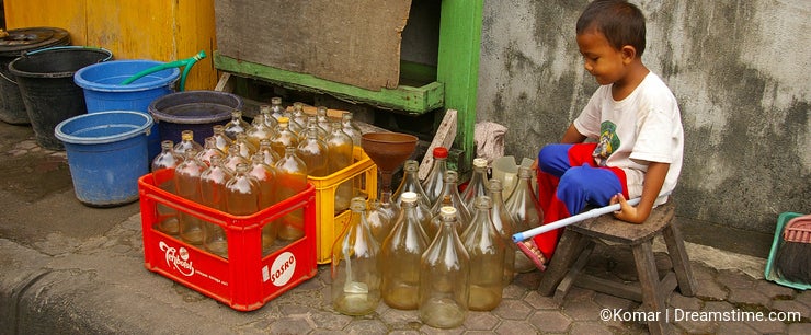 Asian boy with empty petrol bottles