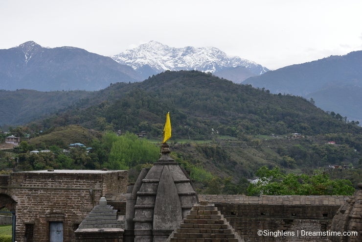 Fragment of ancient Shiva temple at Baijnath, Himachal Pradesh, India with green hills and snowy mountains in the backdrop