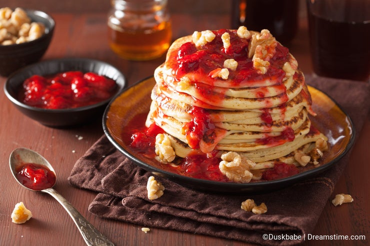 Stack of pancakes with strawberry jam and walnuts. tasty dessert