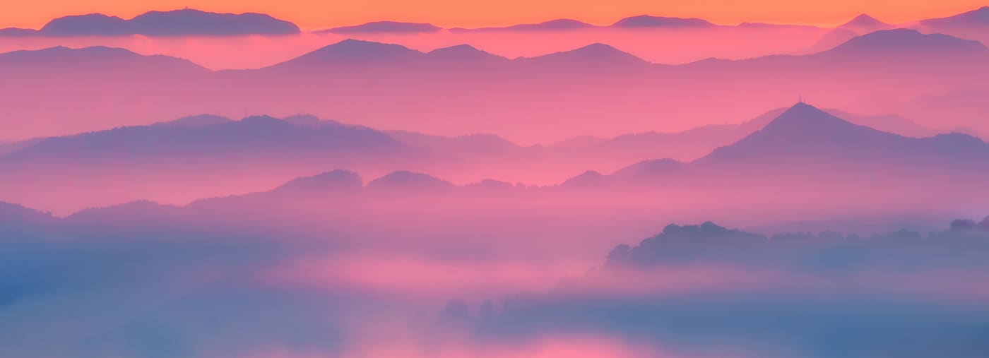 misty mountains silhouettes at sunset
