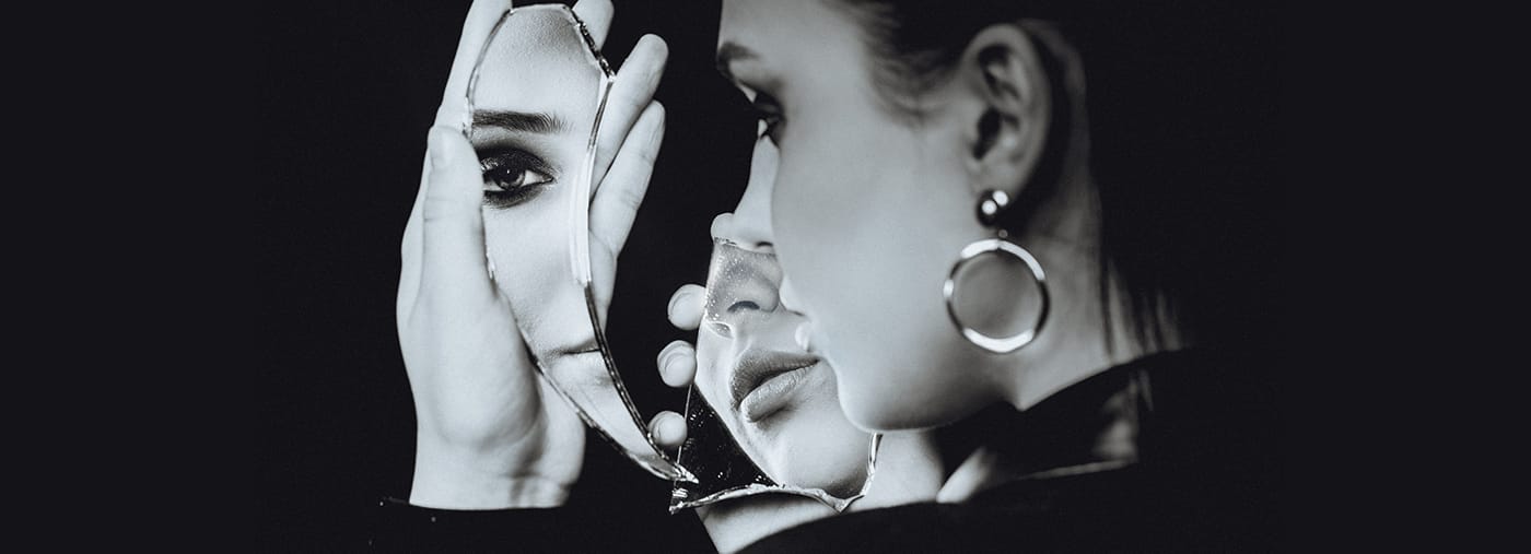 mulher perfeita olhando para o espelho quebrado no fundo preto retrato e branco