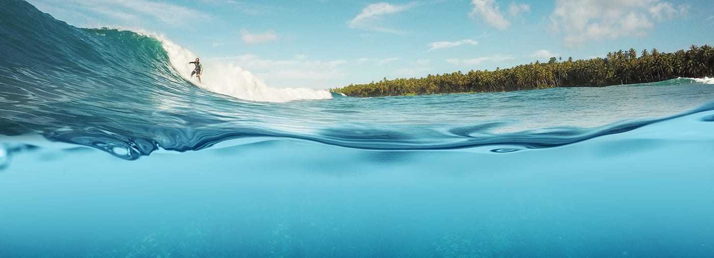 half onderwater van surfer die op een golven in indo surft onderwaterschot dat rif kramp indonesië