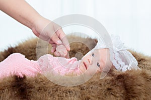 0-1 month Asian newborn baby lie down on brown fur in studio, toddler infant open eye seeking some voice near her, baby open eye
