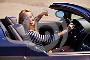 0-60 instantly. a young woman driving in a sports car.