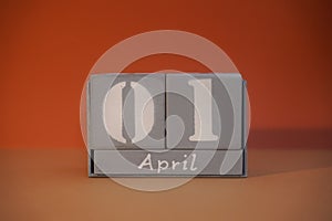 1 April on wooden grey cubes. Calendar cube date 01 April. Fools day, funny date. Concept of date. Copy space for text