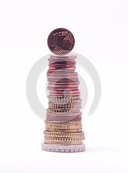 1 cent coin standing on top of stack of euro coins.