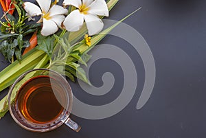 1 cup of tea and a variety of flowers placed on a black table