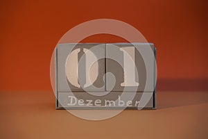 1 Dezember on wooden grey cubes. Calendar cube date 01 December. Concept of date. Copy space for text. Educational cube