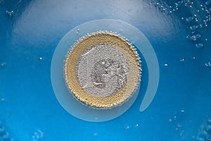 The 1 euro coin sinks in the water