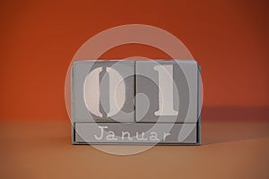1 Januar on wooden grey cubes. Calendar cube date 01 January. Concept of date. Copy space for text. Educational cubes