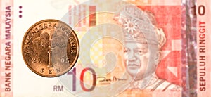 1 malaysian sen coin against 10 malaysian ringgit bank note