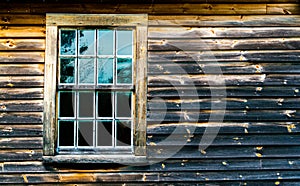 1 multiple paned window in a weathered and charred wooden wall