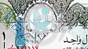 1 Riyal banknote, Bank of Qatar, closeup bill fragment shows Coat of arms depicting sailboats, palm trees and crossed swords
