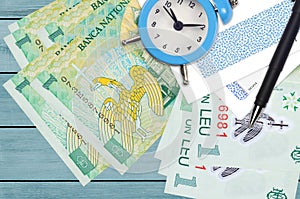 1 Romanian leu bills and alarm clock with pen and envelopes. Tax season concept, payment deadline for credit or loan. Financial