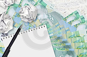 1 Romanian leu bills and balls of crumpled paper with blank notepad. Bad ideas or less of inspiration concept. Searching ideas for
