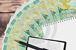 1 Romanian leu bills fan and notepad with contact book and black pen. Concept of financial planning and business strategy