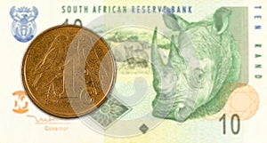 1 south african aforika coin against 10 south african rand banknote