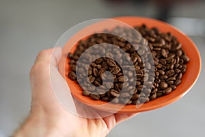 1-st person view, man holding saucer with coffee beans