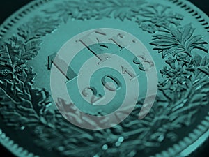 1 Swiss Franc coin close up. Dark turquoise tinted background about economy or business. Blue green banking wallpaper. Money and