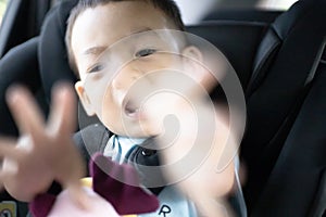 1 Year Old Adorable, an Asian Toddler Boy, Sitting in a Car Seat on a Car While Traveling Looking at the camera
