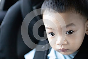 1 Year Old Adorable, an Asian Toddler Boy, Sitting in a Car Seat on a Car While Traveling Looking at the camera