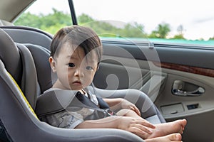 1 Years old Asian Chinese Boy sitting in a car in safety chair