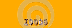 10,000 followers numbers foil balloons on yellow background. Blogger blogging followers concept, top view, flat lay