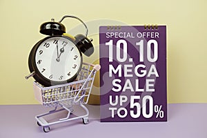 10.10 Mega sale promotion with trolley shopping cart and alarm clcok on yellow background, business background