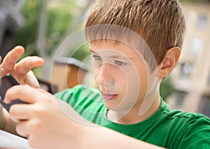 10 - 12 year boy playing with smartphone