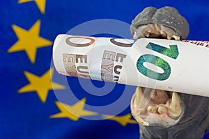 10 Euro note in mouth of a hippo figurine