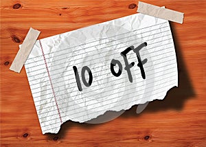 10 PERCENT OFF handwritten on torn notebook page crumpled paper on wood texture background.