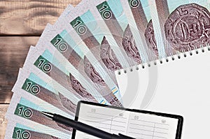 10 Polish zloty bills fan and notepad with contact book and black pen. Concept of financial planning and business strategy