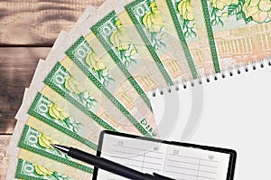 10 Sri Lankan rupees bills fan and notepad with contact book and black pen. Concept of financial planning and business strategy