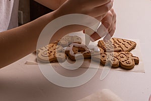 A 10-year-old boy glazes cookies with a culinary bag. Handmade. Children& x27;s creativity