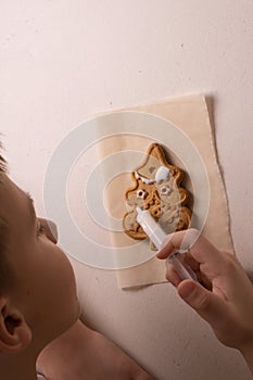 A 10-year-old boy glazes cookies with a culinary bag. Handmade. Children& x27;s creativity