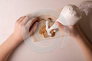 A 10-year-old boy glazes cookies with a culinary bag. Handmade. Children& x27;s creativity