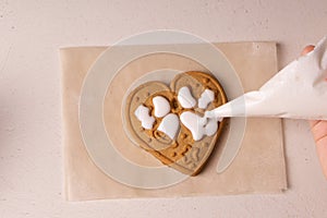 A 10-year-old boy glazes cookies with a culinary bag. Handmade. Children's creativity