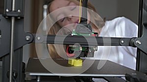 A 10-year-old boy watches the 3D printing process with rapt attention