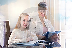 10 years old girl and her teacher. Little girl study during her private lesson. Tutorial and educational concept.