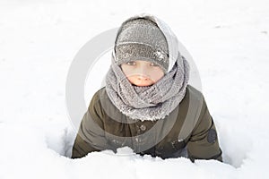 10 yeras boy in winter snow has fun in warm cloth. Cold weather concept close up photo