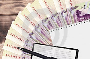 100 Cambodian riels bills fan and notepad with contact book and black pen. Concept of financial planning and business strategy