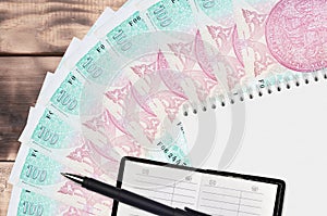 100 Czech korun bills fan and notepad with contact book and black pen. Concept of financial planning and business strategy