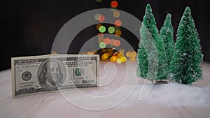 100 dollar bill and artificial Christmas trees. Christmas tree and one hundred dollar bills of dollar against the background of