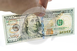 100 dollar bill in the hand. The reverse side is visible on a gleam. Isolated on a white background