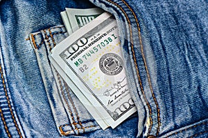 100 dollar bills in blue jeans pocket