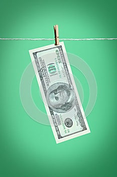 A 100 dollars banknote dries on a rope