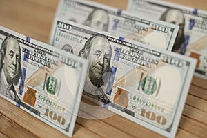 100 Dollars bill and portrait Benjamin Franklin on USA money banknote. Hundred dollar bills on wooden background